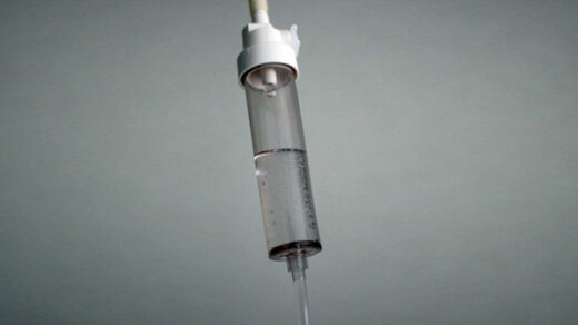 An IV drip in a stark grey room