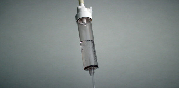 An IV drip in a stark grey room